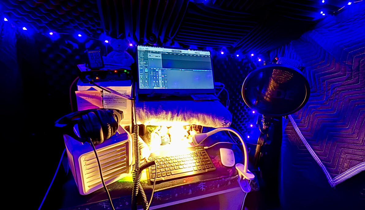 D Casellian's Vocal Booth A vocal booth featuring blue accent lighting with monitor, interface, mic, and headphones all ready to record